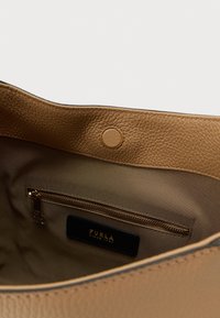 Mięte, teksturowane wnętrze torebki ze skóry w kolorze brązowym z kieszenią na zamek, metalowymi elementami oraz podszewką z tkaniny. Posiada zapięcie na zatrzask.