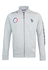 Grå zip-up sweatshirt i bomullsblandning, med blå logotyp och textdetaljer, ribbade muddar och ståkrage.