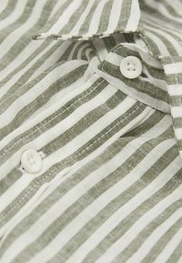 Gestreiftes Hemd mit abwechselnd grünen und weißen Streifen, aus leichtem Stoff gefertigt, mit Kragen, Knopfleiste und weicher Textur.