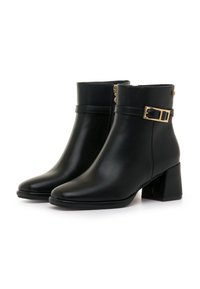Botas de cuero negras hasta el tobillo con un tacón cuadrado, distinguidas por un detalle de hebilla dorada y un acabado suave. Cuentan con cierre de cremallera en el lateral.