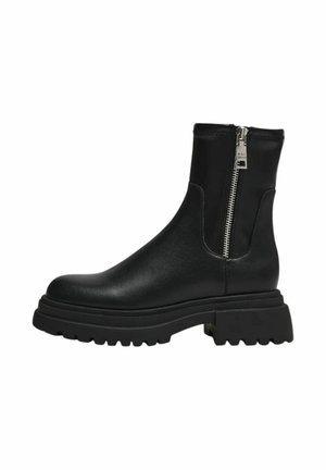Stivaletti neri alla caviglia in pelle liscia, con zip laterale, suola chunky e punta rotonda. Dettagli della suola in gomma testurizzata.
