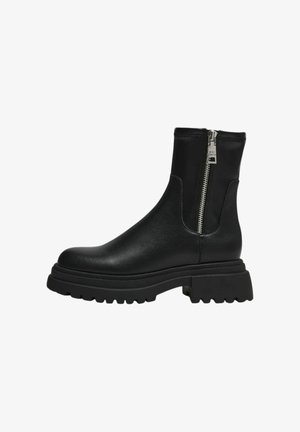 Stivaletti neri alla caviglia in pelle liscia, con zip laterale, suola chunky e punta rotonda. Dettagli della suola in gomma testurizzata.