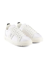 Baskets blanches avec un dessus en mesh, des lacets et une semelle en caoutchouc texturée. Accent noir notable au talon et logo circulaire sur le côté.