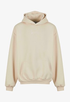 Beige hoodie tillverkad av mjukt tyg, med en ficka fram, ribbade ärmslut och nederkant, samt en diskret vit logotyp på bröstet.