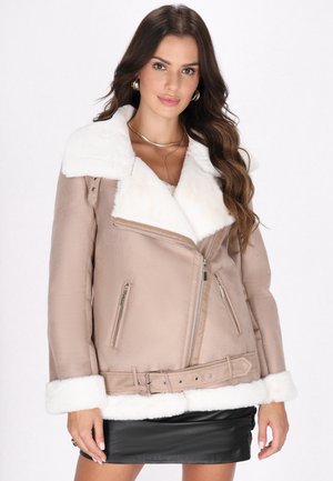 Giacca in finta pelle beige con colletto e polsini in pelliccia sintetica bianca, zip asimmetrica e vita con cintura. Inclusi due taschini laterali.