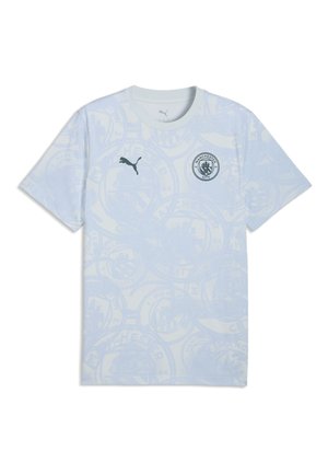 Camiseta azul claro del Manchester City con un patrón sutil del escudo del club, logo de Puma en el lado derecho del pecho y cuello redondo.