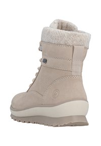 Botín impermeable beige hasta el tobillo con un suave borde de piel de pelo, parte superior de ante texturizado, sistema de cordones y una suela de goma con un patrón de banda de rodadura.