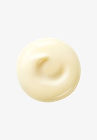 Kremet, glatt fuktighetskrem i en blek gul farge, formet som en swirl, med en blank finish.