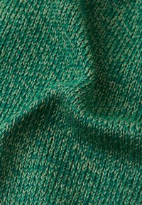 Zielona dziana tkanina o teksturowanym wzorze, z mieszanką ciemnozielonych i jasnozielonych nici, tworząca głębię i wymiar.