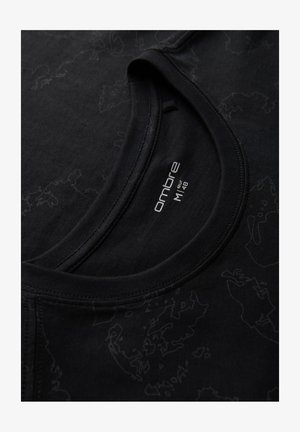 T-shirt noir à col rond avec un motif de carte subtil et une étiquette de taille "ombre M 48" imprimée à l'intérieur du col.