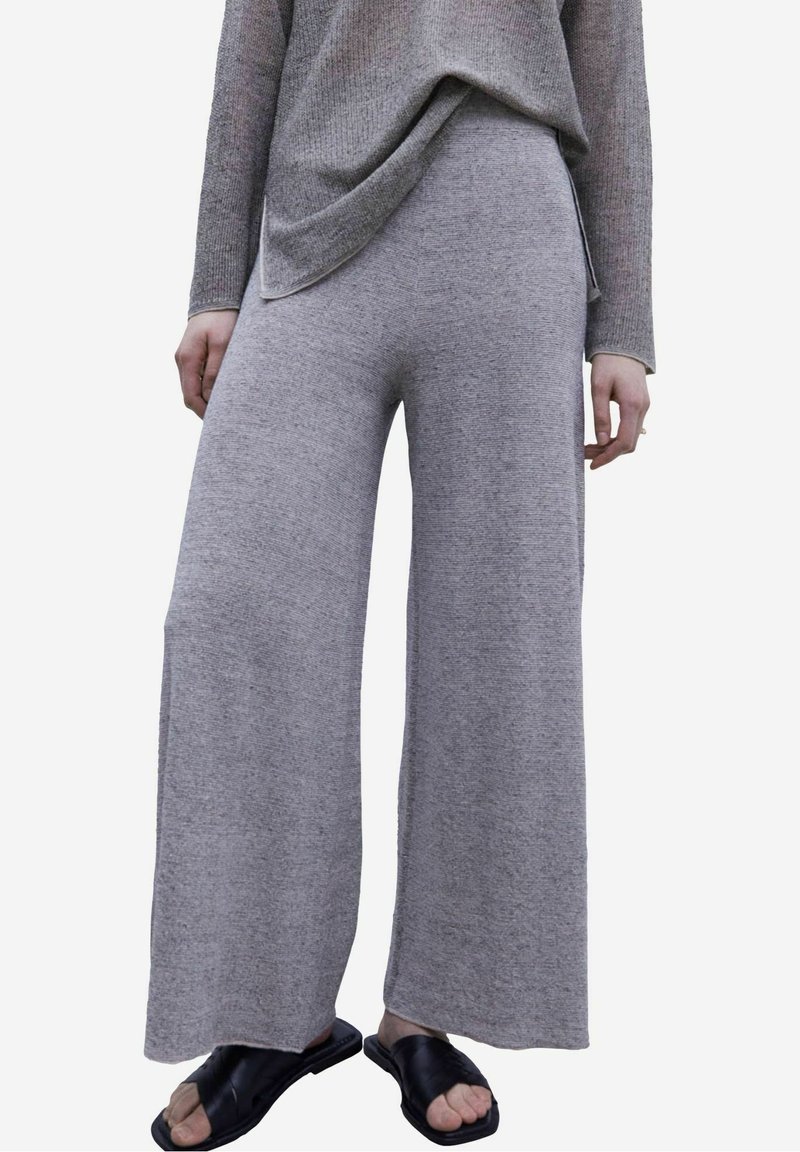 Pantaloni a gamba larga grigio chiaro realizzati in un morbido tessuto strutturato, caratterizzati da un design morbido e una vita alta.