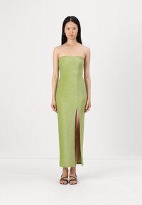 Vestido verde brilhante sem alças, com corpete justo e uma fenda alta até a coxa. Apresenta uma textura suave e um design até ao chão.