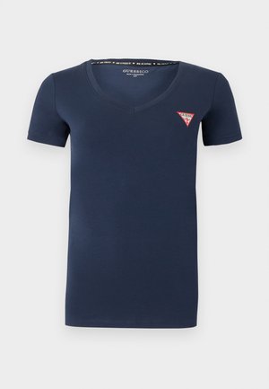 Temno modra majica z V-izrezom in kratkimi rokavi, na levi prsni strani majhen rdeče-beli logotip Guess.