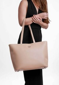 Světle růžová kožená taška přes rameno s hladkým povrchem, dvojitými uchy a akcentem loga. Představena v minimalistickém, otevřeném designu.