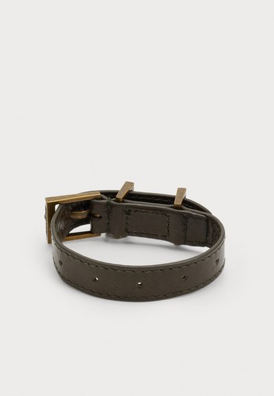 Brățară din piele de culoare verde închis, cu găuri mici pentru ajustare, având o cataramă din metal cu finisaj din alamă pentru o fixare sigură.