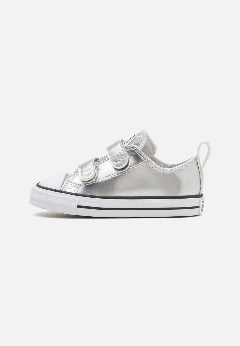 Silver sneaker with a glossy finish, featuring two adjustable Velcro straps, a white rubber toe cap, and a black-striped sole.
