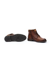Botas de tobillo de cuero marrón con un acabado texturizado, que presentan una cremallera lateral, puntera redonda y un patrón de suela resistente para mejorar el agarre.