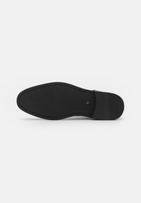 Suela de zapato de cuero negro con acabado liso, forma redondeada, costura delgada en el borde y áreas de tracción de goma. Marcada con el tamaño "42".