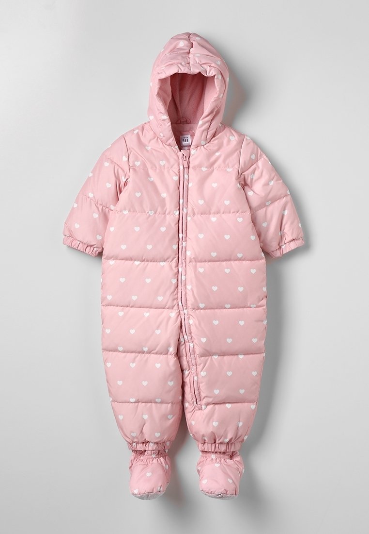 Roze gewatteerde babypak voor de sneeuw met witte hartpatronen, een aangehechte kap, een rits aan de voorkant en ingebouwde voetbedekking.