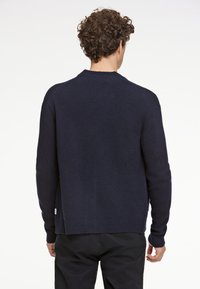 Mörkblå, långärmad tröja i mjuk stickad kvalitet, med en rund halsringning och ribbade ärmslut samt en avslappnad passform.