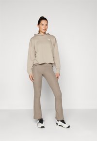 Under Armour MOTION FLARE PANT - Legíny - taupe dusk/black
