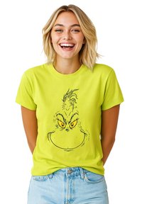 T-shirt verde neon con illustrazione del volto del Grinch contornato in nero, con occhi gialli e tratti facciali ben definiti.