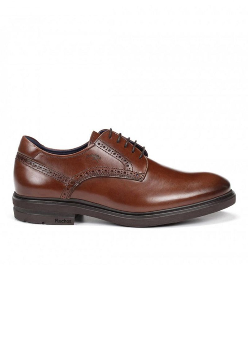 Zapato de vestir de cuero marrón con un acabado suave, perforaciones decorativas y una suela negra resistente. Logo de la marca visible en el lateral.
