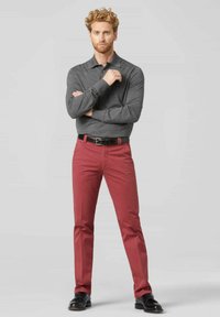 Grijze polo met lange mouwen, gecombineerd met rode chino's, afgewerkt met een zwarte riem en zwarte schoenen. Eenvoudig ontwerp, gladde textuur, op maat gemaakte pasvorm.