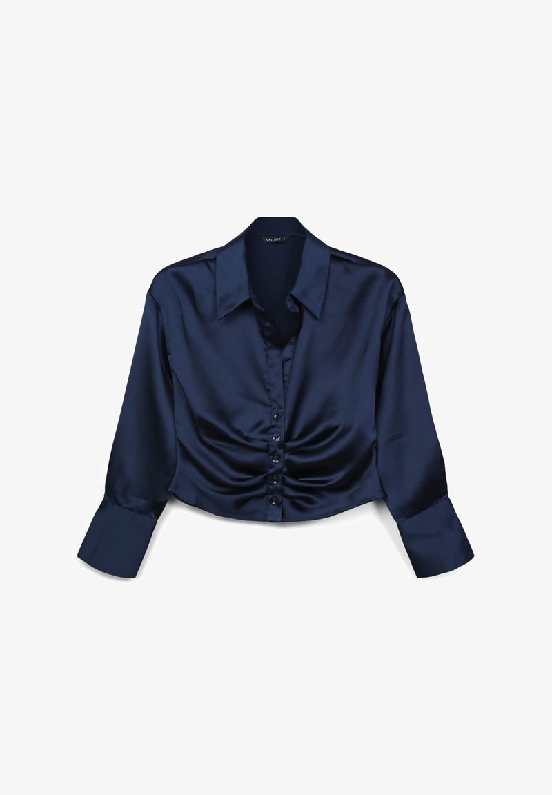 Camicetta accorciata in satin blu navy con maniche lunghe, colletto a punta e chiusura frontale con bottoni; presenta dettagli arricciati sul corpetto.