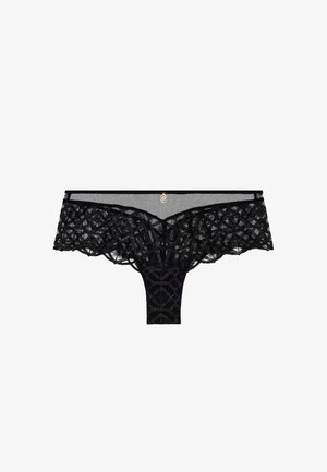 Le string en dentelle noire présente un motif géométrique, un tissu transparent et un accent décoratif doré. Les bords avant festonnés mettent en valeur le design.