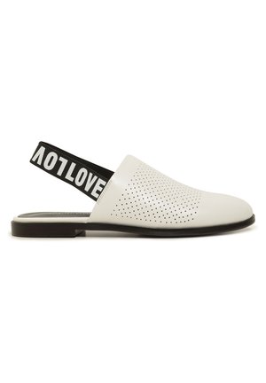 Chaussure blanche en cuir à enfiler avec empeigne perforée et bride arrière élastique noire ornée du texte blanc "LOVE", semelle plate noire.
