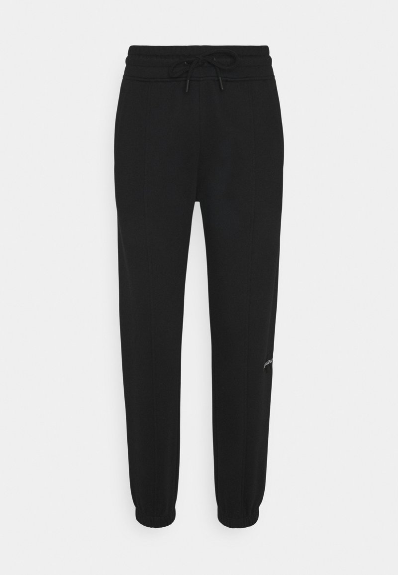 Pantalons de jogging noirs en tissu doux, avec une taille élastique et cordon de serrage, jambes fuselées et un petit logo sur un côté.