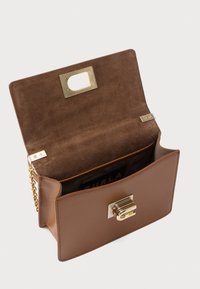 Brun læderhåndtaske med en struktureret form, foring af ruskind og en lås i guldmetal. Har en kæderem og et indvendigt rum.