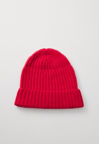 Red knitted beanie with a ribbed texture, folded cuff, and a rounded top. Made from soft yarn, featuring a uniform color throughout.