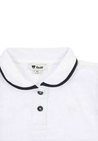 Polo bianco con tessuto testurizzato, colletto nero e dettagli in bottone, con un logo impresso in modo sottile sul petto. Etichetta della taglia visibile.