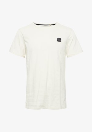 Koszulka z krótkim rękawem w kolorze kremowym, wykonana z bawełny, z okrągłym dekoltem i małą czarną metką marki na lewej piersi.