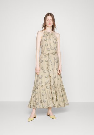 Μάξι φόρεμα σε μπεζ ύφασμα με λουλουδάτο μοτίβο, σχέδιο με θηλιά στο λαιμό, σφιχτή μέση και ρέουσα άκρη. Συνδυάζεται με κίτρινες γόβες.