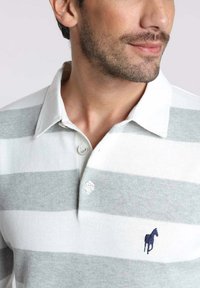 Polo shirt rayé gris et blanc avec un petit logo de cheval navy, featuring une patte de boutonnage et une texture en tricot douce.