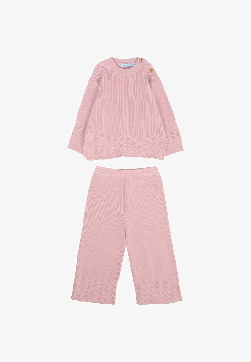 Różowy dziany zestaw składający się z bluzki z długim rękawem z bocznymi guzikami i dekoracyjnym, teksturowanym wzorem na mankietach, zestawiony z pasującymi spodniami typu cropped.