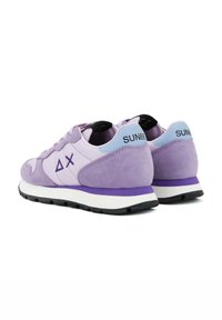 Purple suede sneakers with a white midsole, featuring a light blue heel tab and a geometric logo on the side. Black rubber outsole.