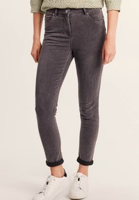 Jeans in denim grigio slim-fit con vita media, cinque tasche e orli arrotolati. Il tessuto ha una consistenza morbida con un leggero sbiadimento.