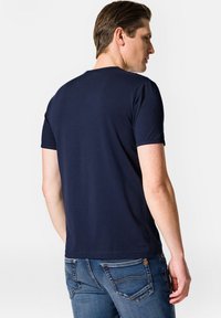 Granatowa bawełniana koszulka z okrągłym dekoltem i krótkimi rękawami, charakteryzująca się gładką strukturą i standardowym krojem, widoczna z tyłu.