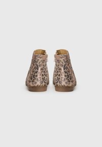 Botines de estampado de leopardo con un acabado suave y texturizado, con cierre de cremallera en el lateral y un tacón bajo y resistente.