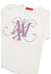 Camiseta de algodón color crema con mangas cortas abullonadas y un logo gráfico en púrpura que presenta las letras M y C entrelazadas en el frente.