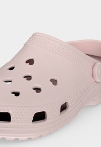 Ροζ ανοιχτό παντόφλα slip-on με υφή στην σόλα και οπές εξαερισμού σε σχήμα καρδιάς στο πάνω και πλάγιο μέρος.