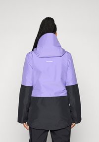 Violet ir juodas šiltas paltas su aukštu apykakle ir gobtuvu. Apatinė dalis juoda, o ant nugaros yra balta prekės ženklo etiketė.