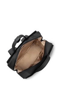 Sac en cuir noir au toucher doux. Intérieur ouvert présenté, avec une doublure beige et sans poches. Poignée supérieure robuste pour le transport.