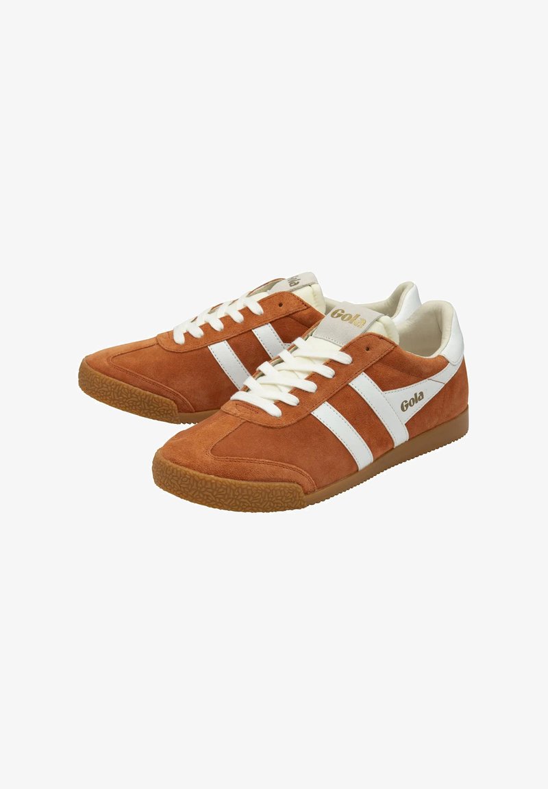 Sneakers in suede marrone con strisce e lacci bianchi. La suola in gomma presenta un motivo testurizzato. Il marchio è visibile sul lato e sulla linguetta.