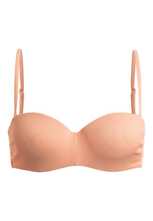 Licht perzik bandeau bh met een geribbelde textuur, verstelbare bandjes en gevormde cups, ontworpen zonder beugel voor een gladde silhouette.