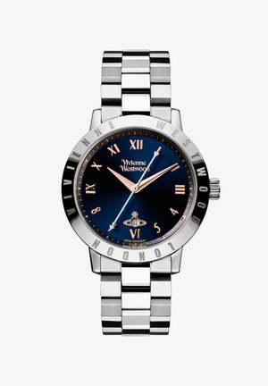 Rustfrit stål armbåndsur med en marineblå urskive, sølvfarvede time-markeringer og et børstet metalarmbånd. Har en datovisning ved seks.
